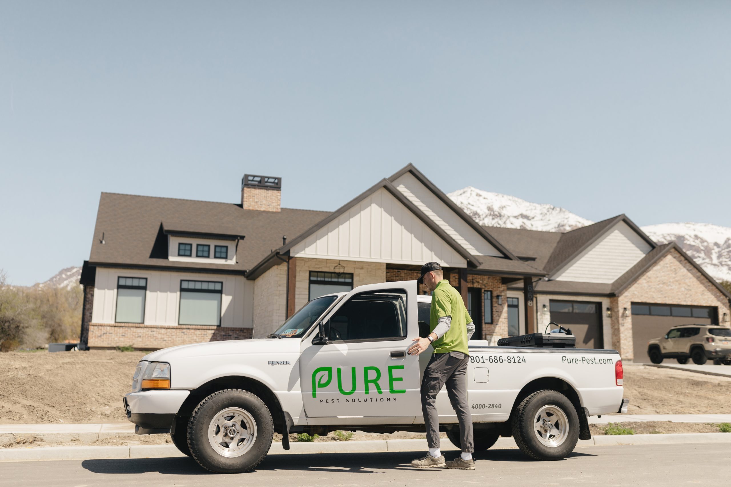 Pure Pest Solutions technician providing professional pest control treatment at a Utah home